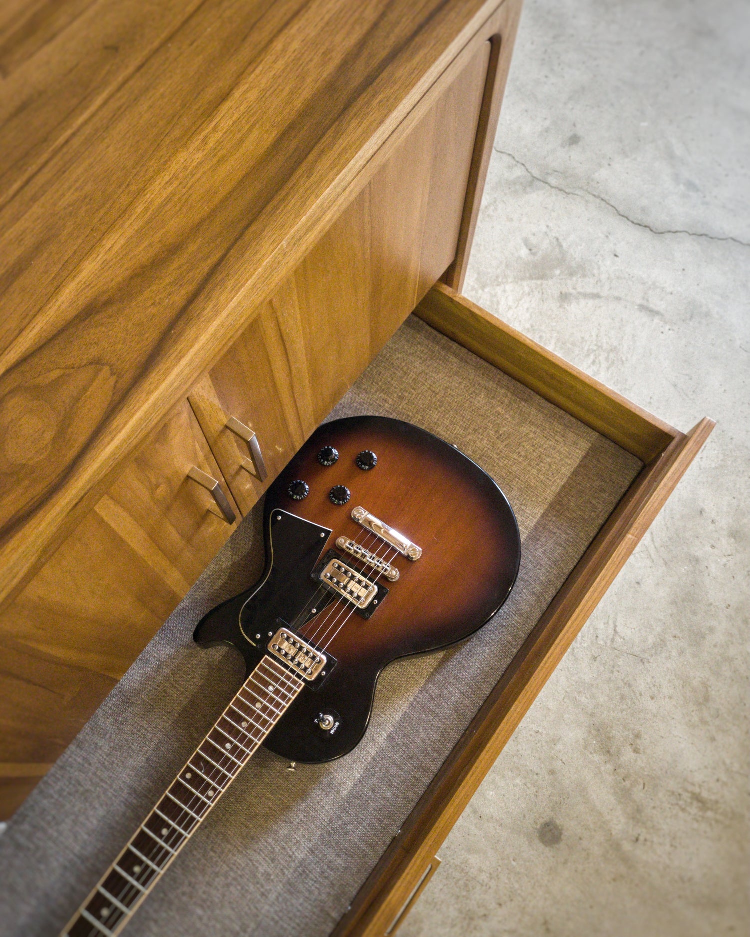 top down photo of guitar inside storage drawer